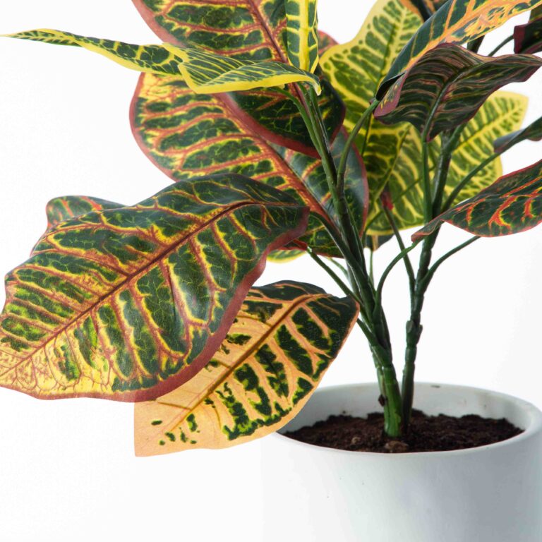 Close-up of leaf foliage texture on this Rainbow Croton Faux Houseplant in White Concrete Planter