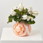 Close-up of vase silhouette detail on this White Cyclamen Leaf and Bloom Faux Floral Arrangement