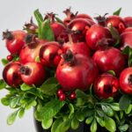 Alternate angle of the Christmas Crown of Pomegranates Bowl Centerpiece Arrangement showing full arrangement shape
