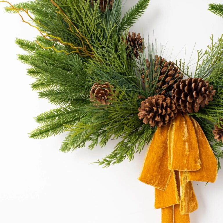 Close-up of blooms and berries on this Evergreen Forest Mixed Greens Gold Velvet Bow