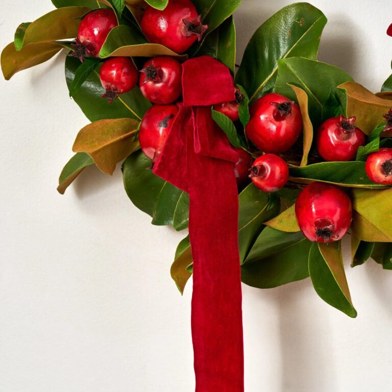 Close-up of blooms and berries on this Real Touch Magnolia Leaf Door Christmas Wreath