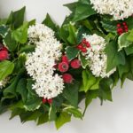 Close-up of blooms and berries on this Holiday Tidings - Holly Leaf Door Holiday Wreath