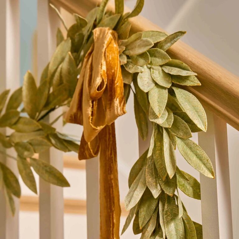 Close-up of greenery along the garland on this Sage Green Gold Brushed Bay Holiday Mantle