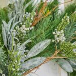 Close-up of blooms and berries on this Seeded Eucalyptus and Christmas Pine Door Holiday Wreath