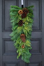 Close-up of swag tail detail on this Classic Holiday Greens and Pinecone Door Winter Swag