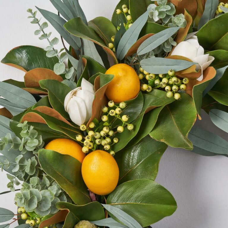 Close-up of blooms and berries on this Fresh Citrus Real Touch Magnolia Spring Estate Wreath