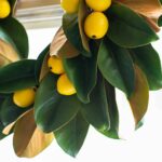 Close-up of blooms and berries on this Real Touch Magnolia Leaves with Lemon Mini Wreath