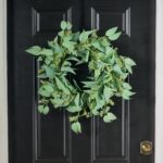Alternate angle of the All Seasons Faux Blade Eucalyptus Front Door Wreath showing wreath face
