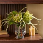 Alternate angle of the Protea Paradise - Lifelike Green Water Illusion Arrangement showing bloom arrangement