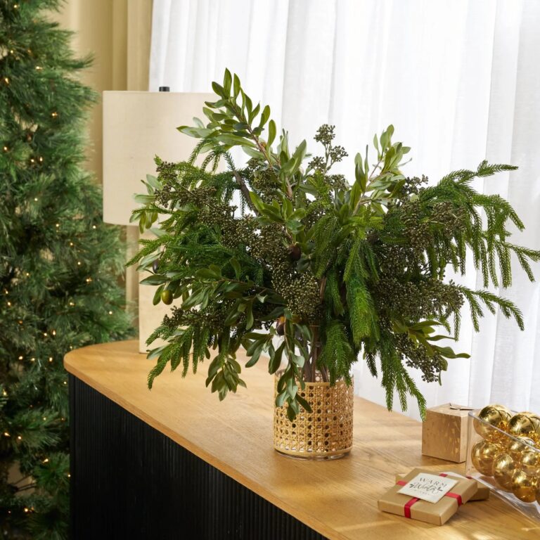 Close-up of vase silhouette detail on this Real Touch Norfolk Pine, Olive Water Illusion Arrangement