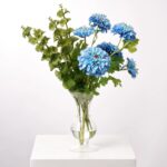 Alternate angle of the Lifelike Blue Ombre Zinnia Blooms Water Illusion Arrangement showing bloom arrangement