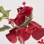 Close-up of vase silhouette detail on this Elegant Burgundy Orchid and Holly Mini Holiday Arrangement