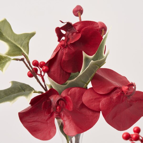 Close-up of vase silhouette detail on this Elegant Burgundy Orchid and Holly Mini Holiday Arrangement
