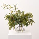 Alternate angle of the Real Touch Mixed Winter Greenery Water Illusion Arrangement showing bloom arrangement