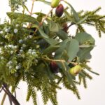 Close-up of vase silhouette detail on this Real Touch Mixed Winter Greenery Water Illusion Arrangement