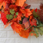 Close-up of blooms and berries on this Orange and Green Ombre Maple Fall 28' Wreath