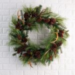Detail view of layered greenery detail from the Northern Elk Faux Antler Door Holiday Wreath