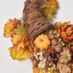 Close-up of blooms and berries on this Harvest Homecoming - Artichoke, Pumpkin, Thanksgiving Cornucopia Wreath
