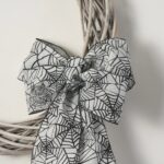 Close-up of blooms and berries on this White Washed Wicker Willow Wreath Spiderweb Halloween Bow