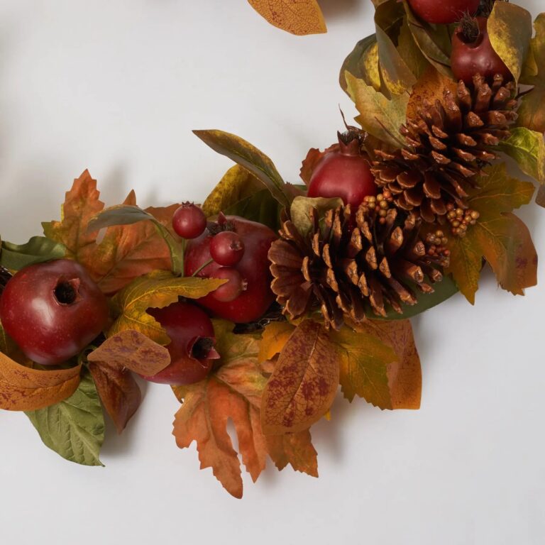 Close-up of greenery along the garland on this Red Pomegranate, Faux Pinecone Fall Mantle Garland