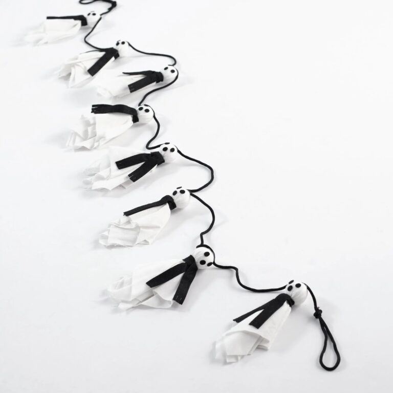 Close-up of greenery along the garland on this BOO White Ghost in Black Hanging Fabric