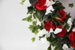 Close-up of blooms and berries on this Red Rose, White Bellflower Day Heart Wreath