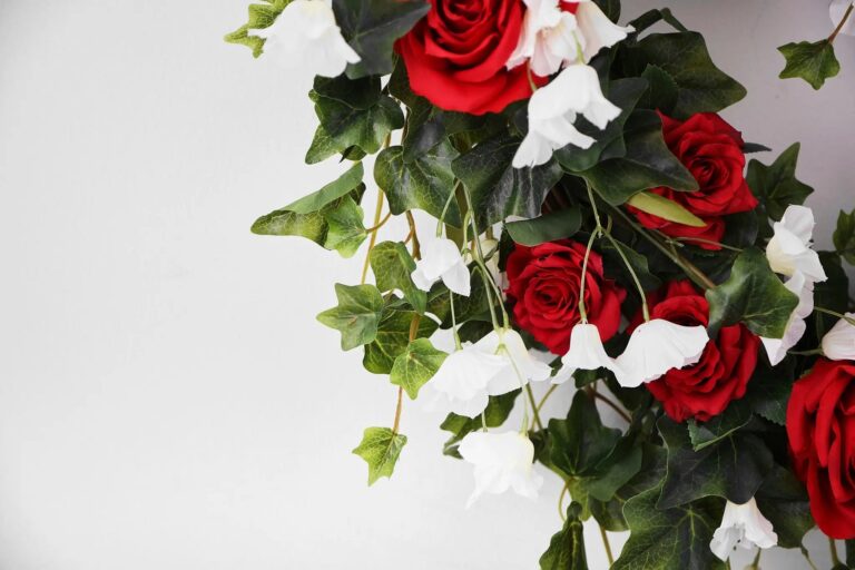 Close-up of blooms and berries on this Red Rose, White Bellflower Day Heart Wreath