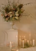 Alternate angle of the Distressed Metal Urn Vase Metal Urn Vase showing bloom arrangement