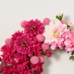 Close-up of blooms and berries on this Cute As A Button Front Door Wreath