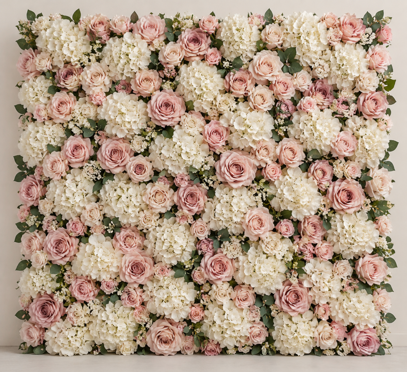 A straight-on view of an artificial flower wall panel covered in blush roses and cream hydrangeas