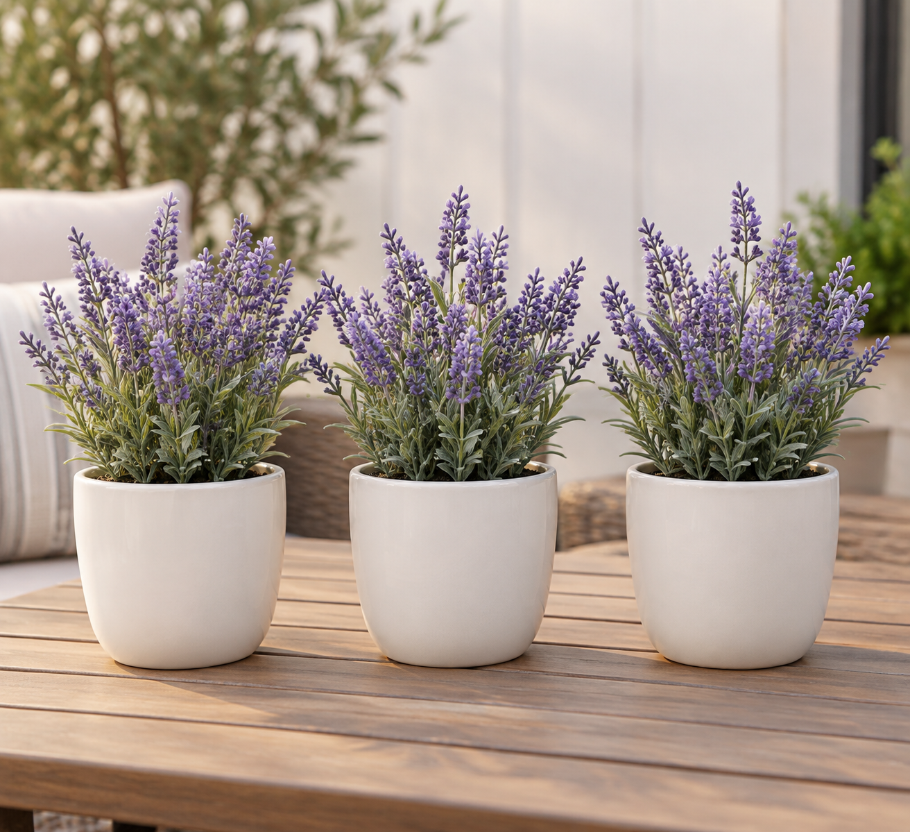Artificial lavender flowers planted in small white ceramic pots on a patio table