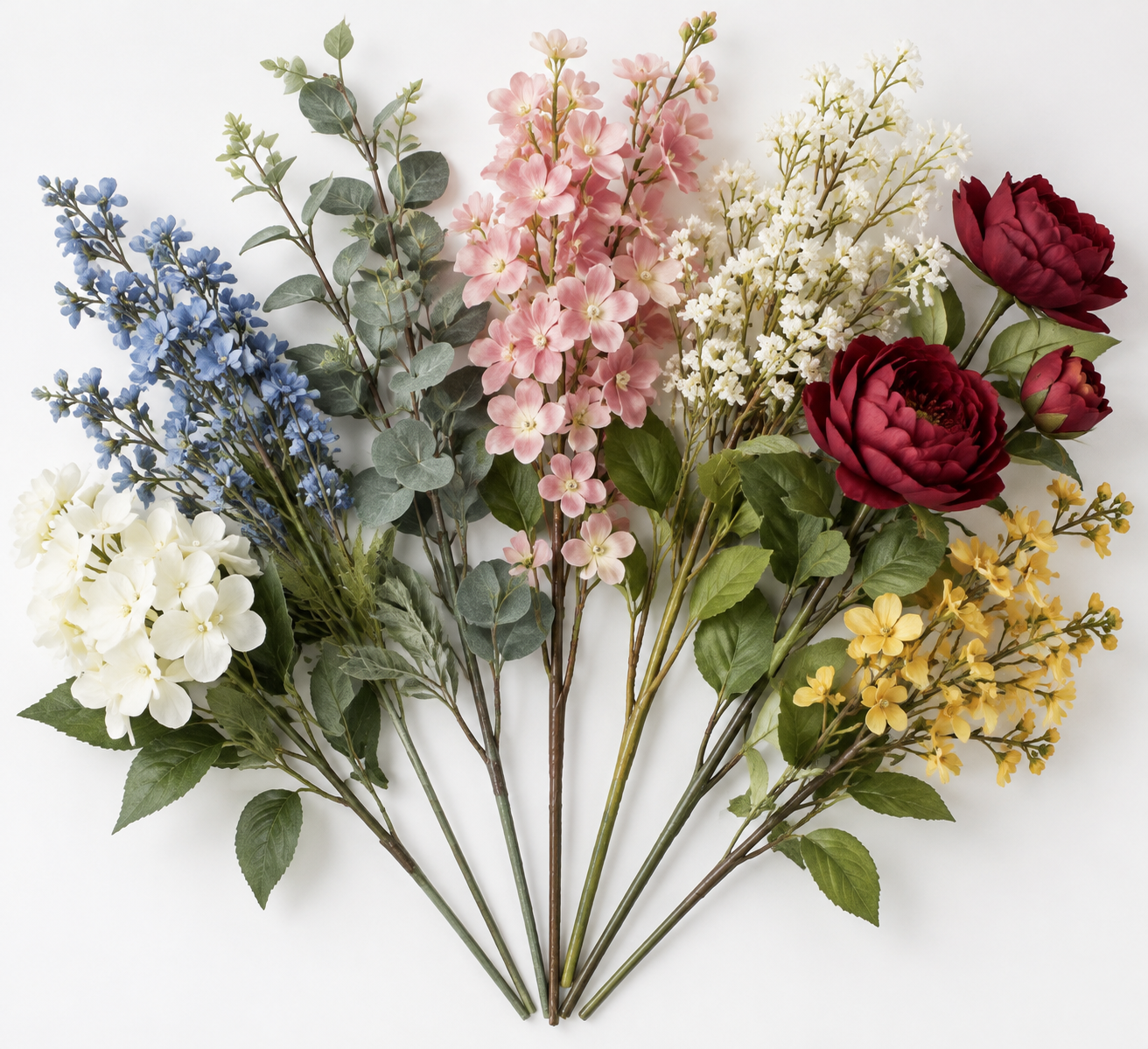 Six artificial flower stems fanned out against a white background: white hydrangea, blue delphinium, eucalyptus greenery, pink blossoms, baby's breath with deep red peonies, and small yellow flowers