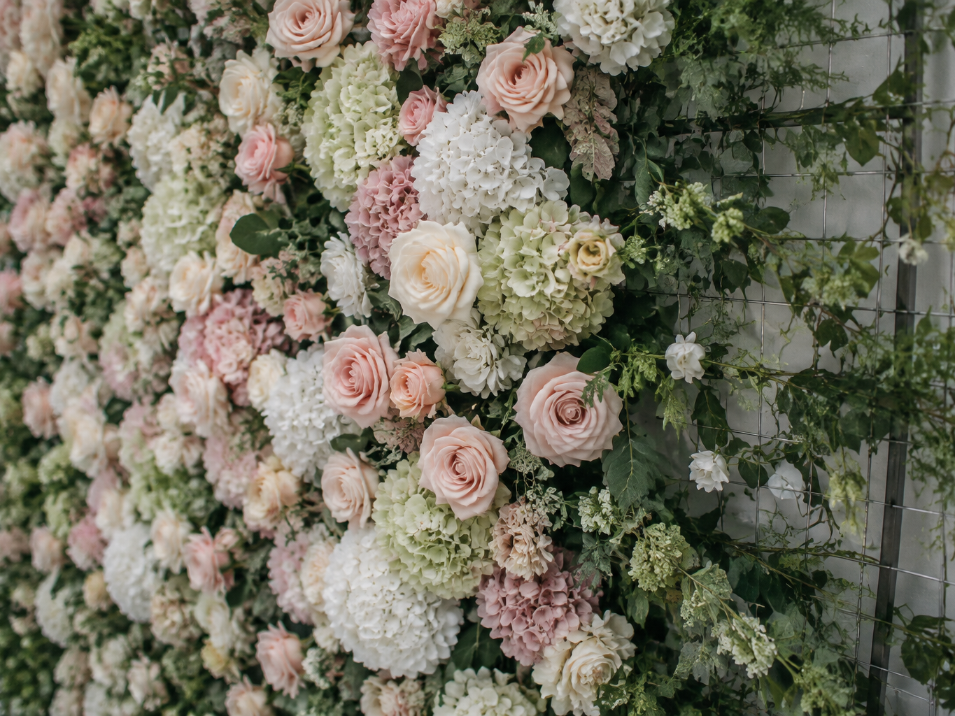 Completed flower wall section with graduated density fading into greenery at the edge