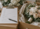 Wedding flower checklist on a clipboard with labeled boxes of artificial bouquets and boutonnieres